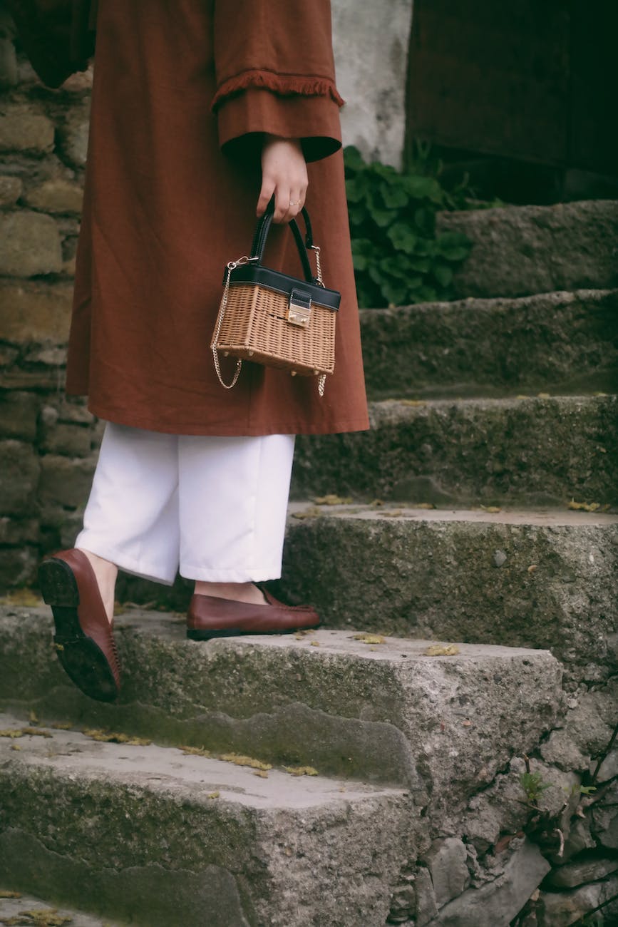 woman holding a wicker bag walking up the steps