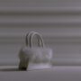 a white small bag with fur on a white surface