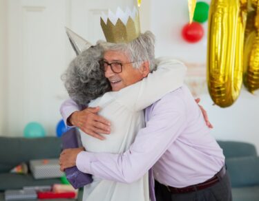 elderly man hugging elderly person