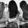 grayscale and selective focus photography of three women