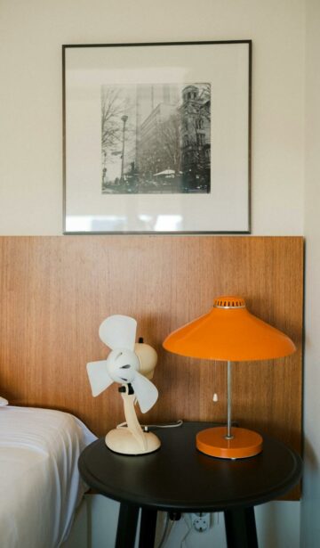 old fashioned fan and lamp on a table on a bedroom
